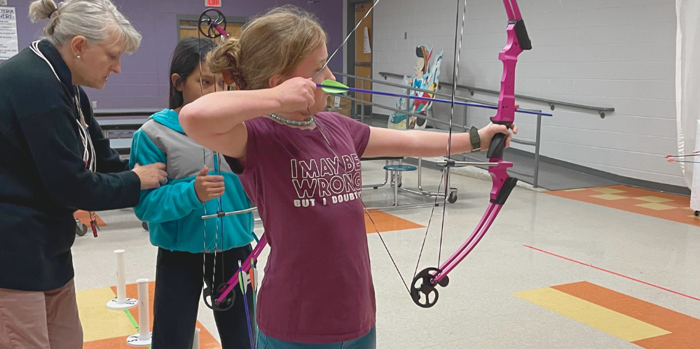 student with a bow practicing archery